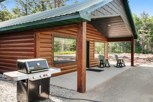 a log cabin with a grill and a patio at The Bear in Conover