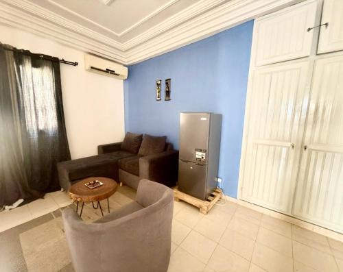 a living room with a couch and a refrigerator at Jade guest House in Dakar