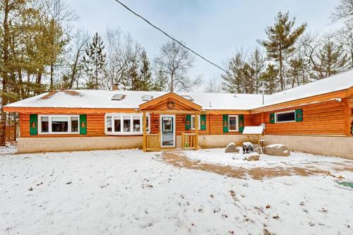 a house with snow on the ground in front of it at Stormy Point Cabin in Conover