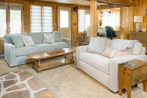 a living room with two couches and a table at Stormy Point Cabin in Conover