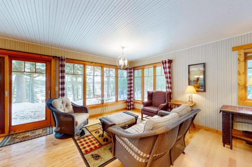 a living room with a couch and chairs and windows at Moon Ridge Lodge in Saint Germain