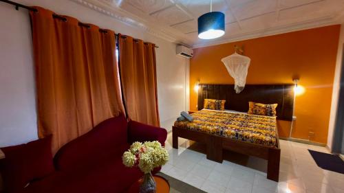 a bedroom with a bed and a couch and a chair at Jade guest House in Dakar