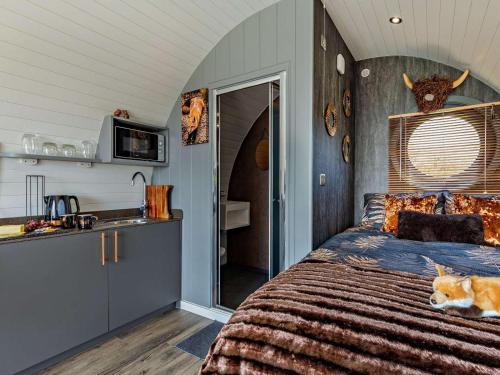 a bedroom with a bed with a dog sitting on it at 1 Bed in South Brent oc-86947 in South Brent