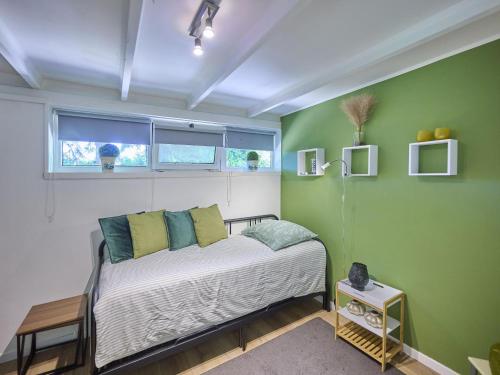 a bedroom with a bed and a green wall at Bungalow Sonnerust in Lanaken