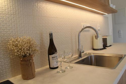 a kitchen counter with a bottle of wine and wine glasses at Villa Martha in Benitses