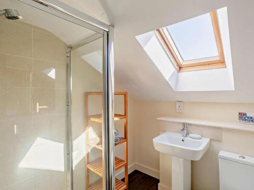 a bathroom with a shower and a sink and a skylight at 2 Bed in Holmfirth oc-emley in New Mills