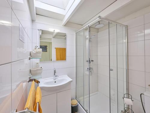 a bathroom with a glass shower and a sink at Bungalow Sonnerust in Lanaken