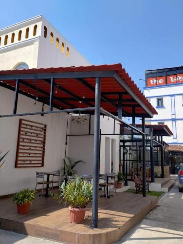 awning on the side of a building with tables and benches at Hotel CHOLOA in Cholula
