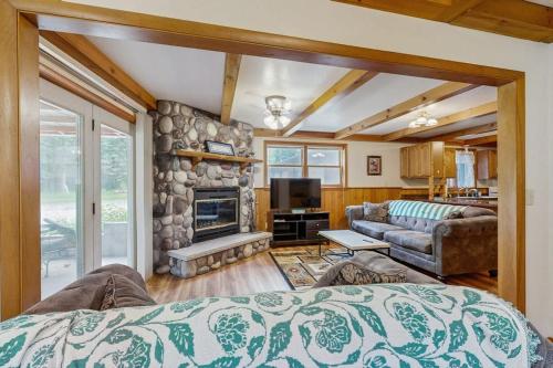 a living room with a stone fireplace and a couch at Rustic Woodland Retreat- Unit A in Arkdale