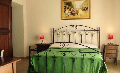 ノートにあるL'Antico Trappetoのベッドルーム1室(緑と白のベッド、ランプ2つ付)