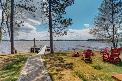 a group of chairs sitting on the grass by the water at The View on Found Lake in Saint Germain