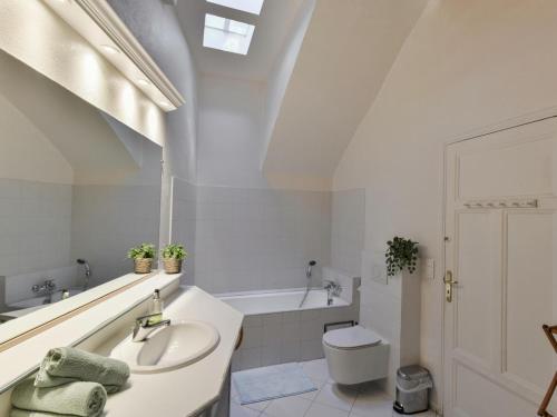 a white bathroom with a sink and a bath tub at Paulette in Éze
