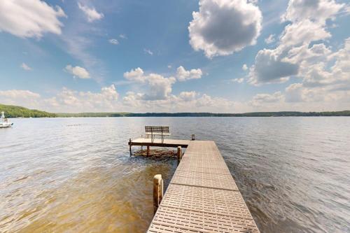 a dock in the middle of a lake with a boat at Flagpole Point in Phelps