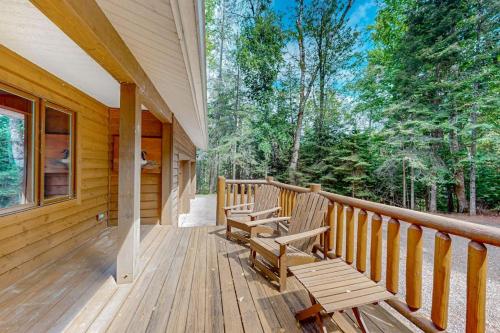 a porch of a cabin with two benches on it at Konkey's Kabin in Saint Germain