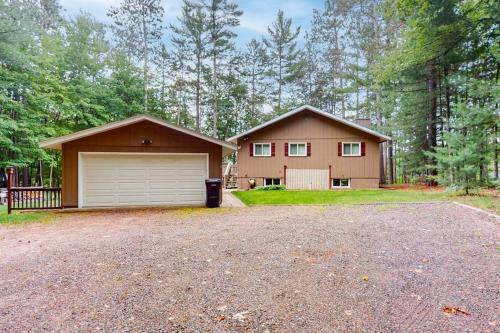 a large house with a garage and a driveway at Hillis House in Arbor Vitae