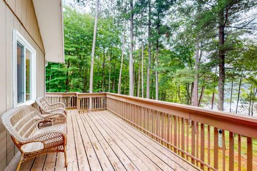 a porch with two wicker chairs on a wooden deck at Hillis House in Arbor Vitae