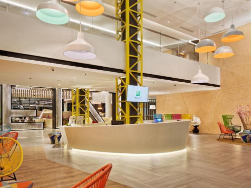 a lobby with a waiting area with colorful chairs at ibis Styles Batam Nagoya in Nagoya