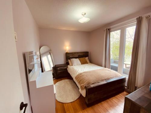 a bedroom with a bed and a large window at 5 bedroom Waterfront house in Tracadie