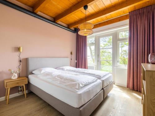 a bedroom with a large white bed and a window at de Sedyk in Pietersbierum