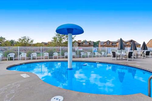 a pool at a resort with chairs and umbrellas at Sunset Condominiums: Golf View in Arkdale