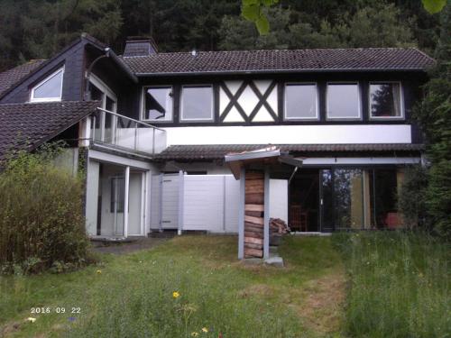 ein Schwarz-Weiß-Haus mit Garage in der Unterkunft Ferienwohnung Dähne in Allagen