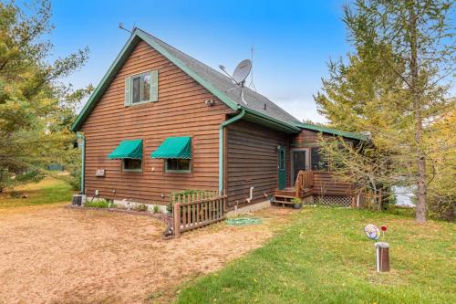 a house with green awnings on the side of it at RTLCMP Lakehouse in Arbor Vitae