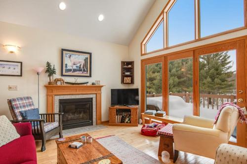 a living room with a fireplace and a tv at RTLCMP Lakehouse in Arbor Vitae
