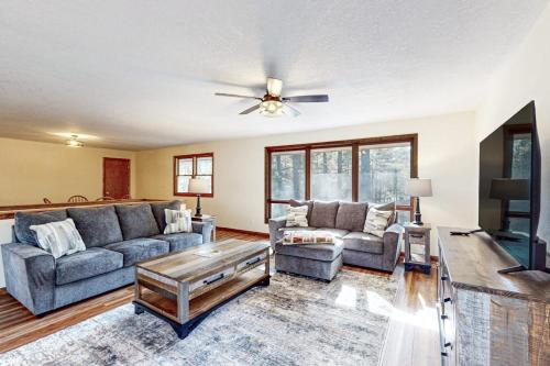 ein Wohnzimmer mit zwei Sofas und einem Deckenventilator in der Unterkunft Mitchell Point Cottage in Eagle River