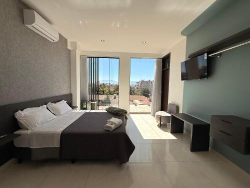 a bedroom with a large bed and a large window at Forty 125 in Tarija