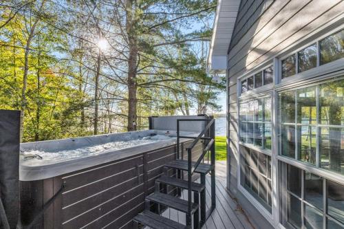 a hot tub on a deck next to a house at North Twin Lake House in Phelps