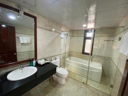 a bathroom with a sink and a toilet and a tub at Beachfront Bungalow Cuu Long in Phú Quốc