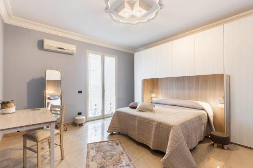 a bedroom with a bed and a table and a desk at Casa Amica in Avola
