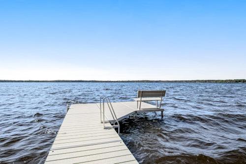 a bench sitting on a dock in the water at Summer Breeze in Sayner