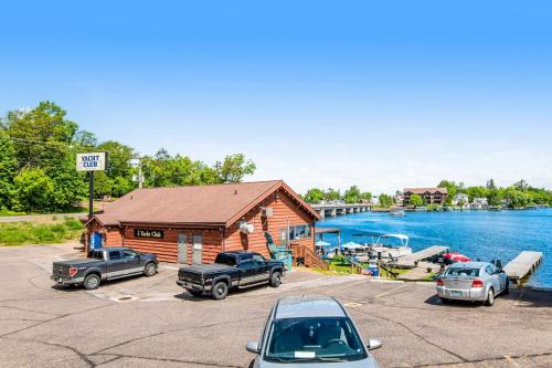 a cabin with cars parked in front of a lake at Lake Minocqua Lakeview in Minocqua