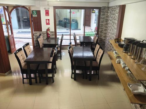 a row of wooden tables and chairs in a restaurant at Hostal Ñustas INN in Machu Picchu