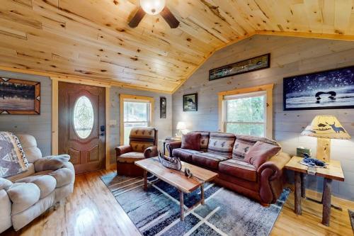 a living room with leather furniture in a log cabin at The Korn Krib- Main level in Oxbo