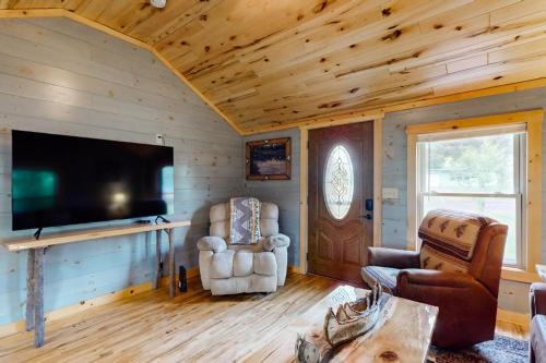 a living room with a flat screen tv in a log cabin at The Korn Krib- Main level in Oxbo