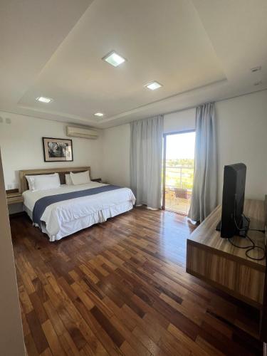 a bedroom with a bed and a flat screen tv at Ramada by Wyndham Furnaspark in Formiga