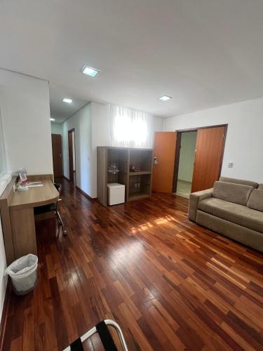 a living room with a couch and a table at Ramada by Wyndham Furnaspark in Formiga
