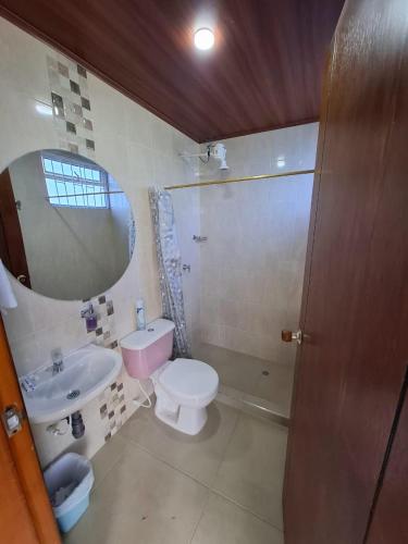 ein Badezimmer mit Waschbecken, Toilette und Spiegel in der Unterkunft Suame in Sogamoso