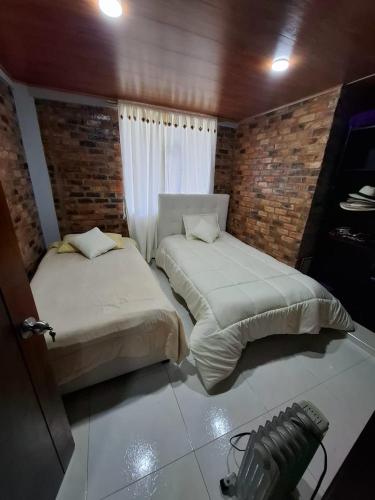 ein Schlafzimmer mit zwei Betten und einer Kamera darin in der Unterkunft Suame in Sogamoso