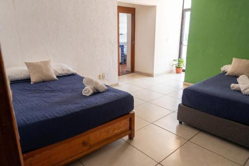 a bedroom with two beds with blue comforters at Casa en Providencia, 4 cuartos, Estacionamiento in Guadalajara