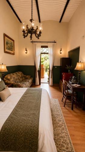 a bedroom with a bed and a table and a chandelier at Hacienda Gobernadores Boutique Stay in a Historic 19th-Century Hacienda in Mexico City