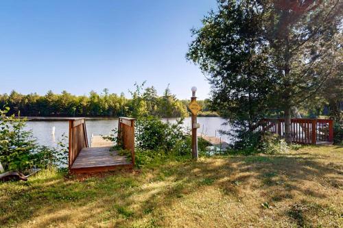 a wooden deck in a yard next to a lake at The Hunters Den in Mercer