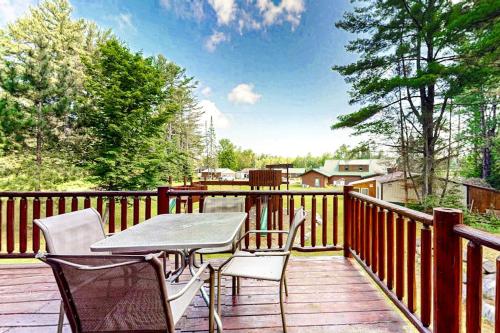 a patio with a table and chairs on a deck at Pine Tree House in Mercer