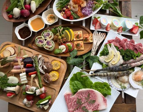 a table topped with lots of different types of food at グランコテージベンガルの森 in Nasu