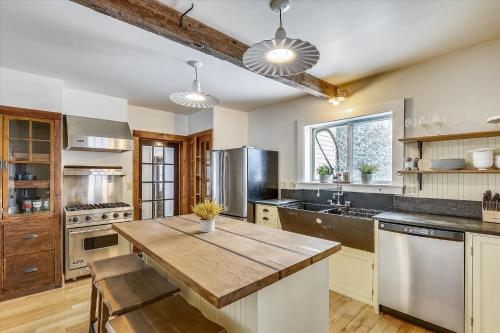 a large kitchen with a wooden counter top and a table at Cozy Villager in Stowe