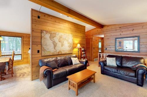 a living room with two leather couches and a table at Chanticleer Inn: Hudson House in Eagle River