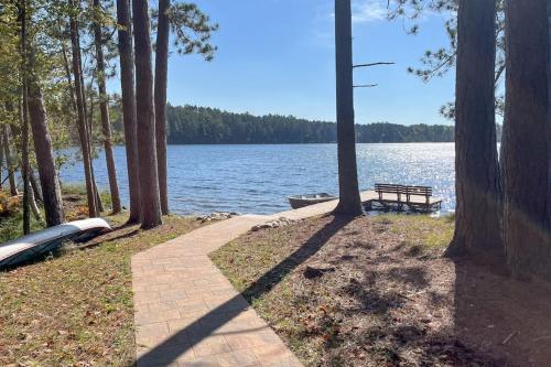 a walkway next to a lake with a bench at Chanticleer Inn: Hudson House in Eagle River