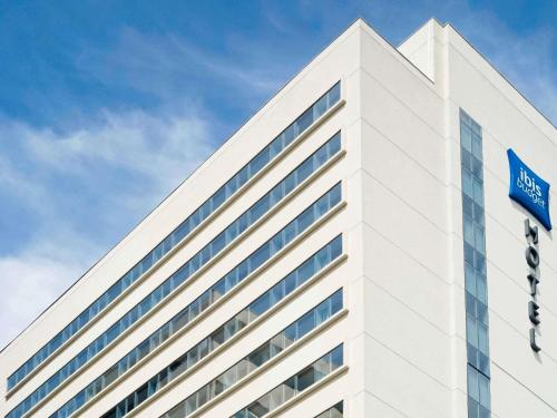 a white building with a blue street sign on it at ibis budget Osasco in Osasco